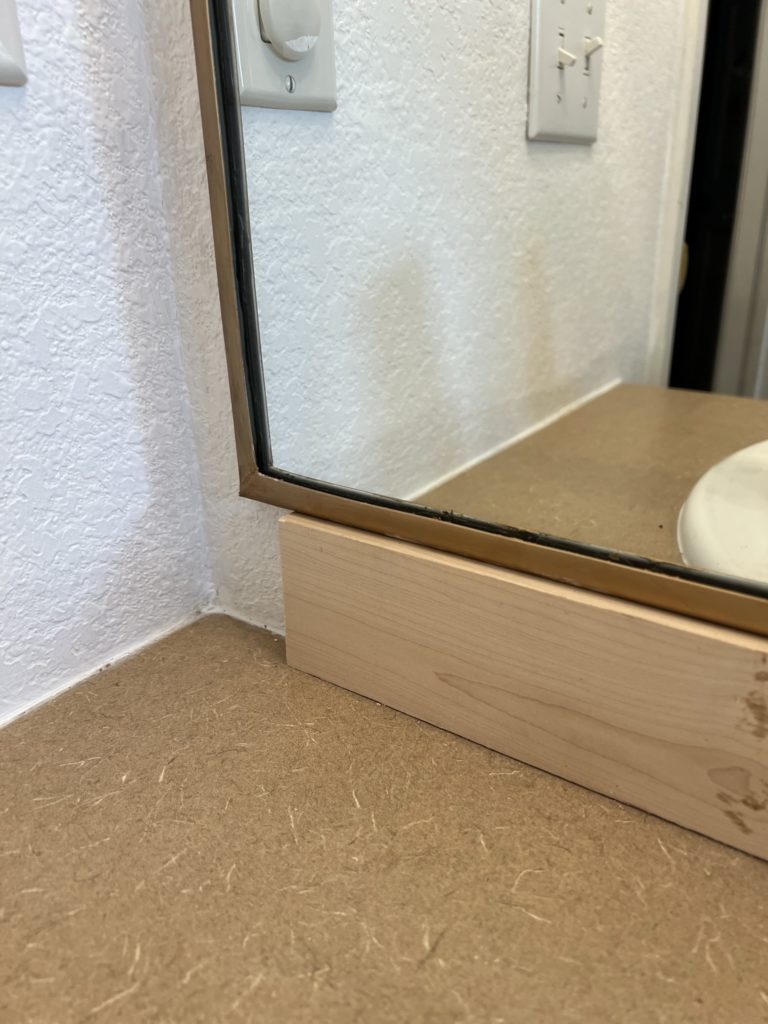 prop  mirror on 2x4 cleat for secure installation